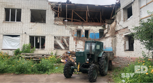 A tractor and the wreckage of a school in the village of Chervona Dolyna